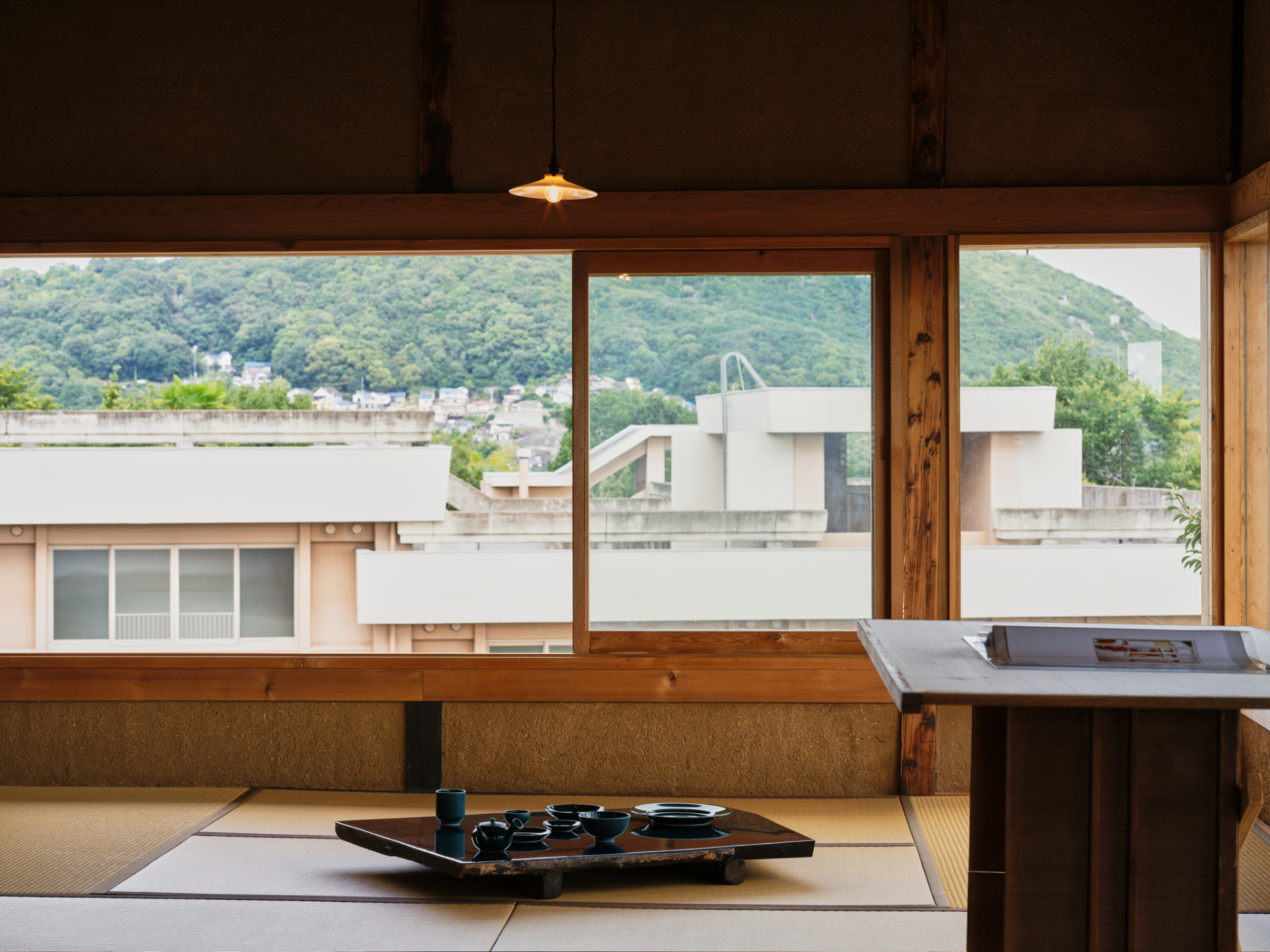 Tatami room with tableware and hillside view