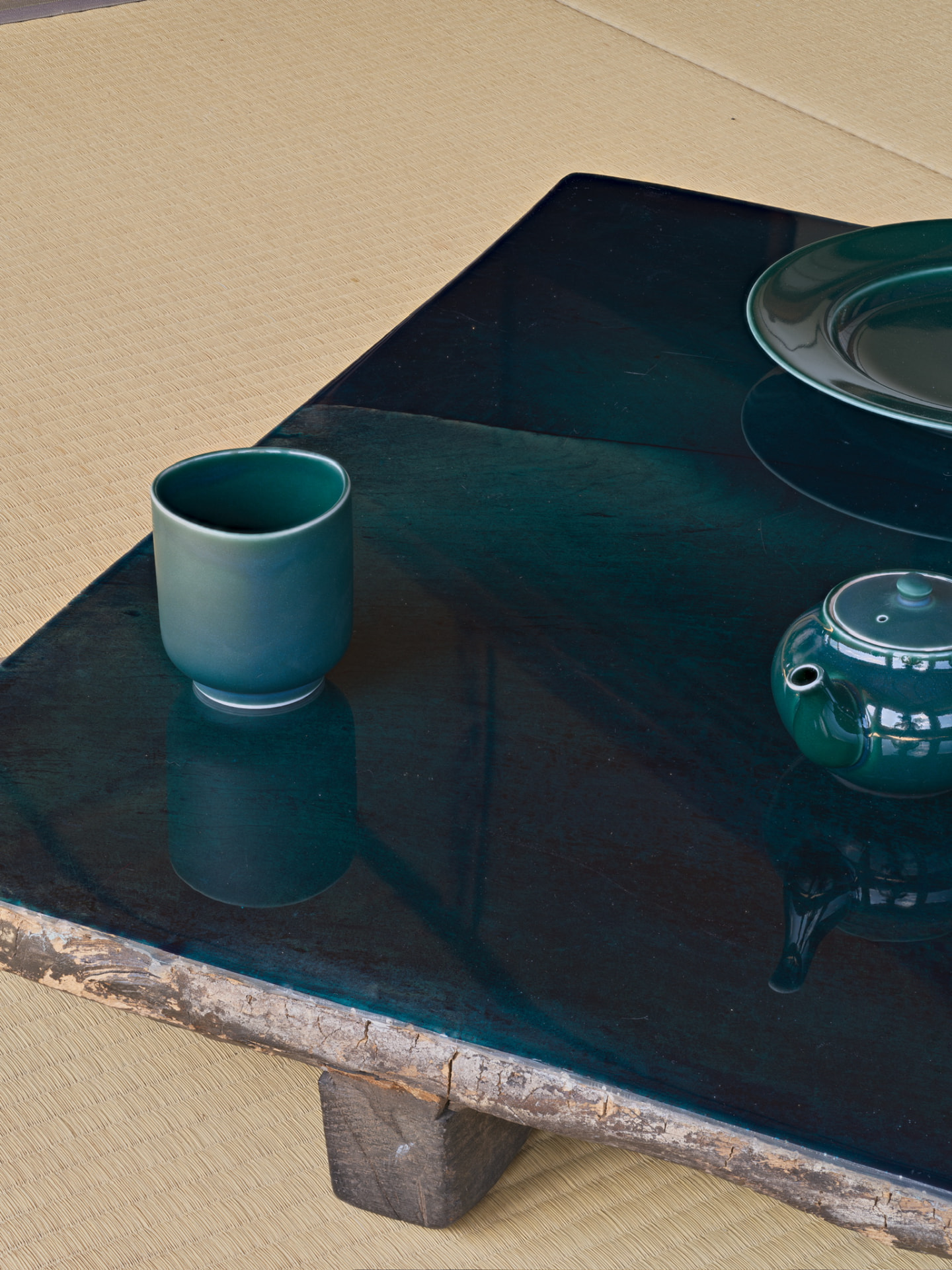 Green glazed cup and teapot on a lacquered table