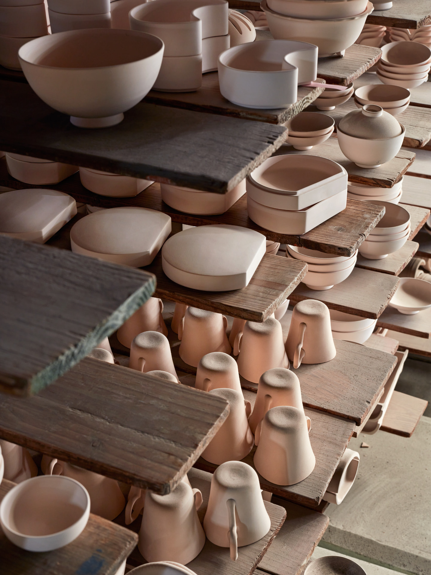 Unglazed ceramic ware drying on wooden boards